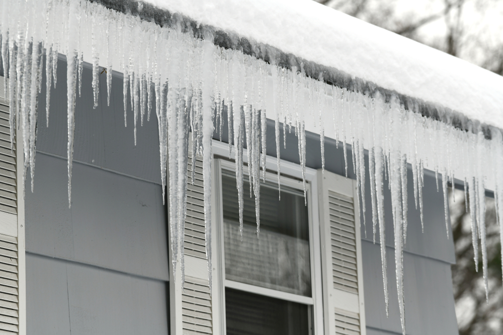 Icicles hanging from house roof in winter.