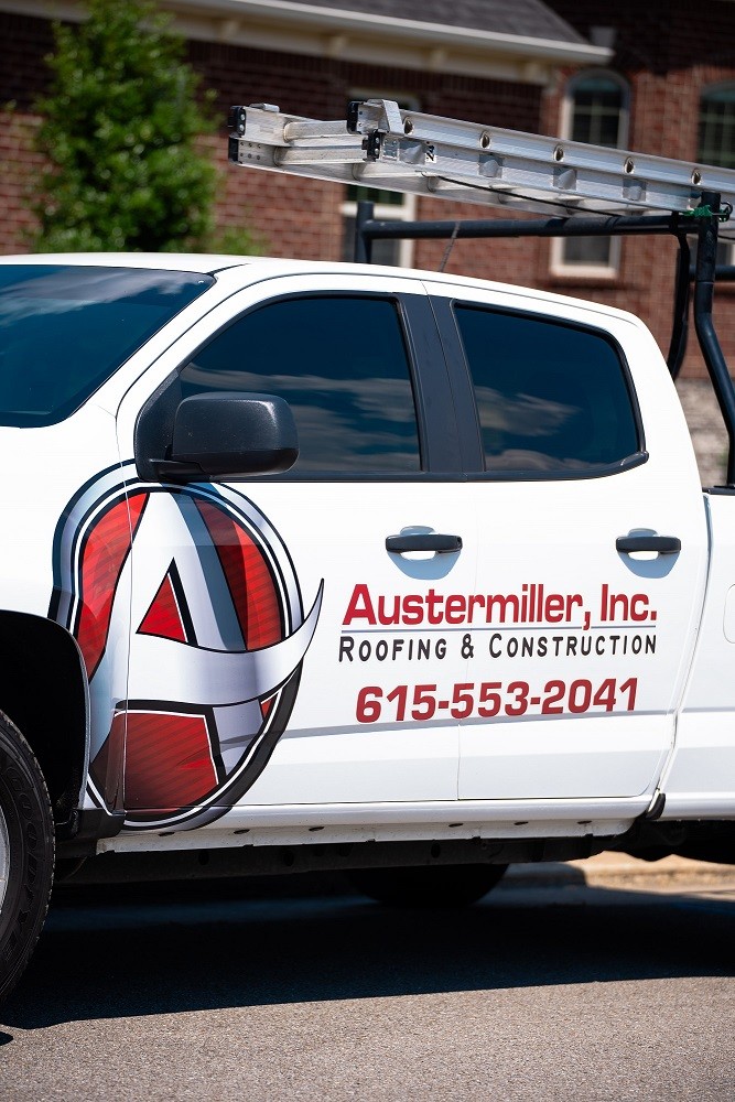 Man repairing roof near a gutter